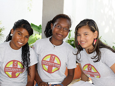 Tres jóvenes en Barranquilla, Colombia, leen el manual del Cuerpo de Salud de Jóvenes