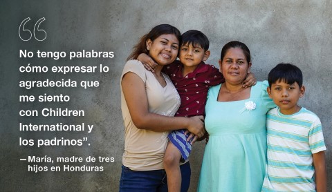María y sus hijos sonriendo enfrente de su casa