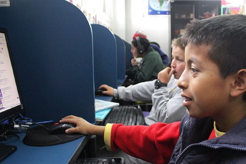 un niño sentado frente a una computadora