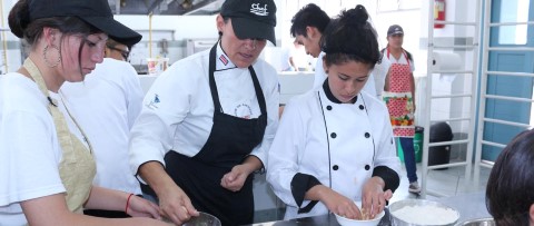 a group of people preparing food in a kitchen