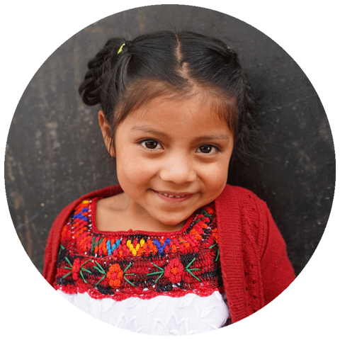 early childhood aged girl smiling at camera wearing red
