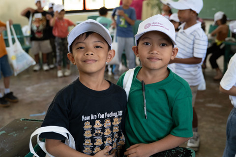 two boys wearing hats and smiling at the camera