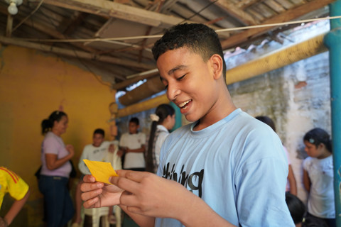 teenage boy reading a yellow paper