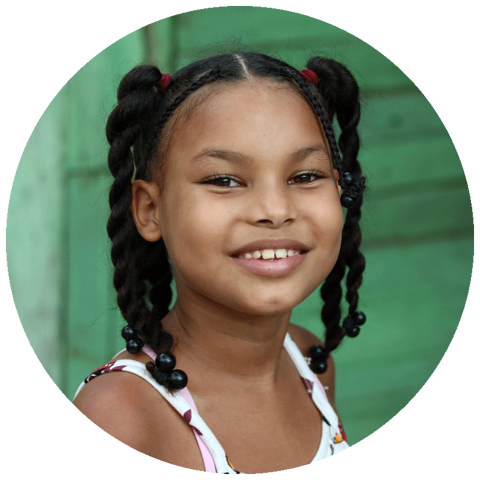 young adolescence age girl smiling at camera against a green wall