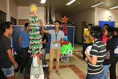 Un joven presenta su obra de arte hecha de materiales reciclados a los jueces.