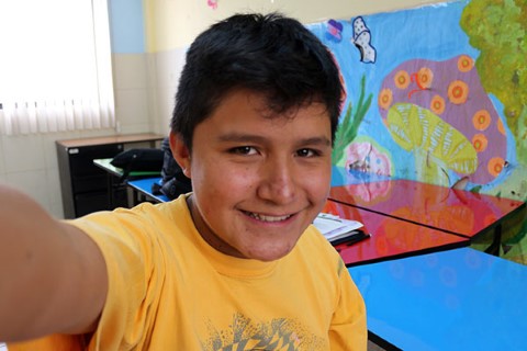 Jaime en una camiseta amarilla se toma una foto. 