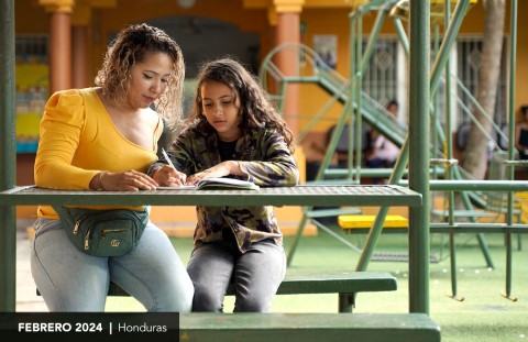 Una mujer y una niña sentadas en una mesa