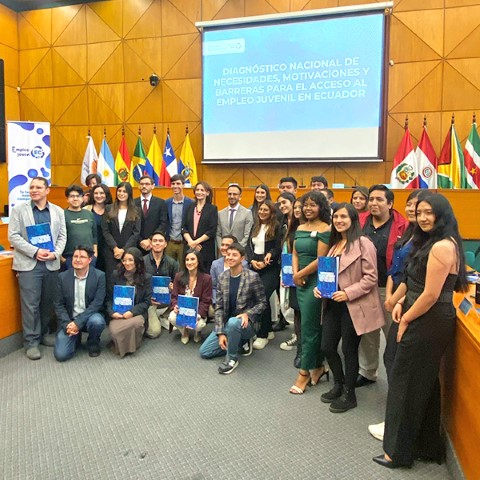A group of professionals pose in front of a podium at the Simon Bolivar Andean University in Ecuador