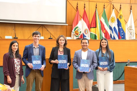 Children International and Empleo Joven staff stand in row while holding printed copies of the joint study
