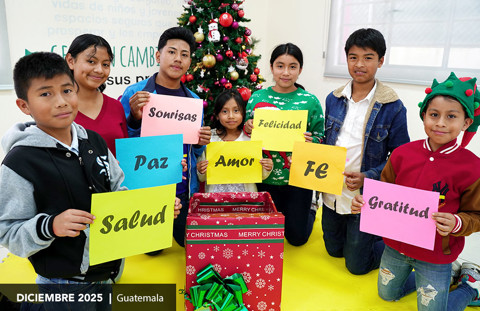 Children in Guatemala pose in front of a Christmas tree