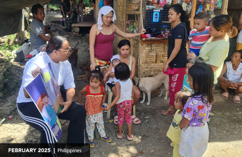 man reads to children in the Philippines