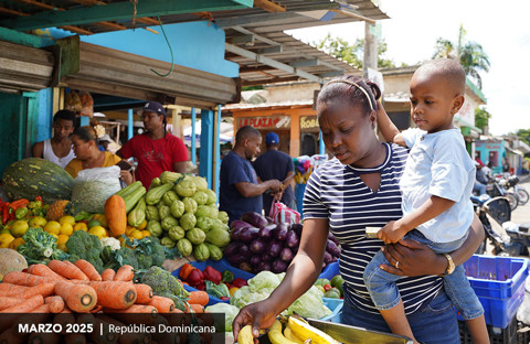 una mujer elige verduras en un mercado