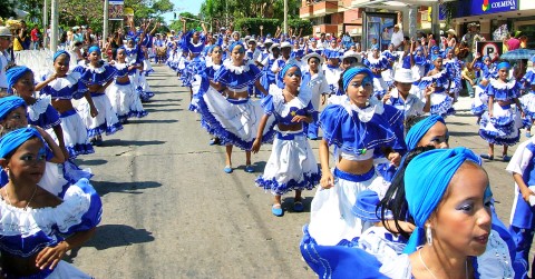 a group of children dressed in traditional costumes dancing in the street