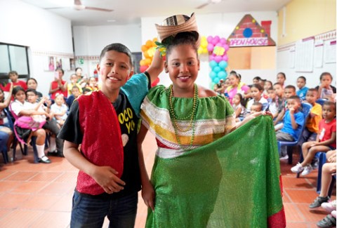 two children dressed in typical costumes posing in front of the camera