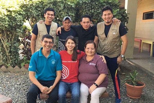 group shot of 7 people smiling in courtyard in Honduras