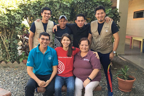 Foto de grupo de siete personas sonriendo en un patio de Honduras