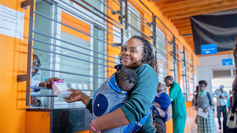 Woman with infant receiving medicines at a clinic.