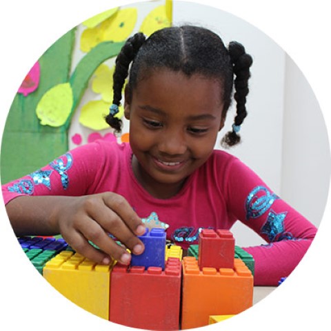Una niña jugando con bloques en un salón de clases
