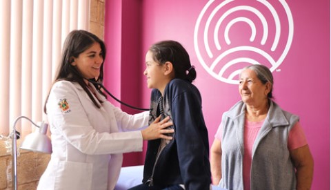 un médico escucha los latidos del corazón de una niña con un estetoscopio