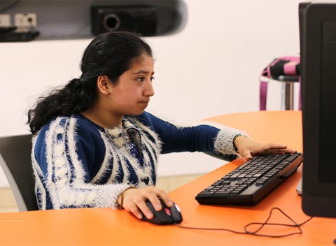 a woman in a blue shirt using a computer