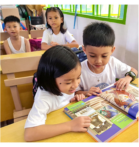 two little kids reading a book
