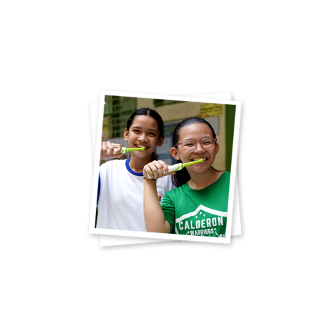 two young girls brushing their teeth
