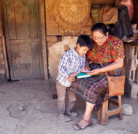 a woman reading a book with a little boy