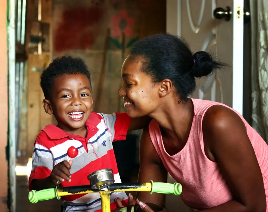 mom looking at her son looking at you with a big smile on his face, grateful for the opportunities